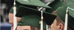 Graduating students wearing green caps.