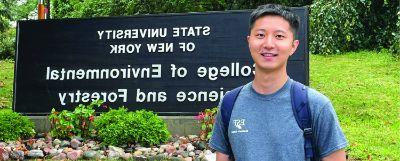 Student standing in front of the SUNY 网赌平台 sign on Forestry Drive.