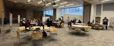 Faculty seated at tables during a workshop.